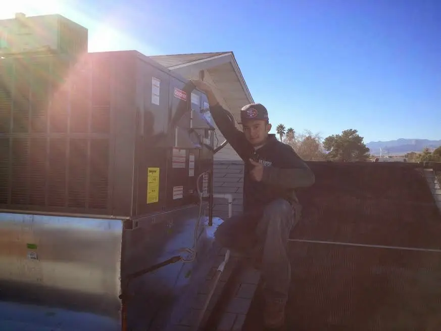 HVAC technician performing Air Duct Cleaning on a rooftop unit in Missoula