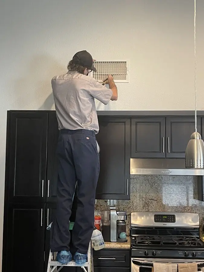 Technician inspecting an air vent during HVAC service in Missoula